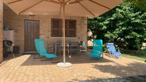 a patio with a table and chairs under an umbrella at La Casa delle Ciliegie in Assisi