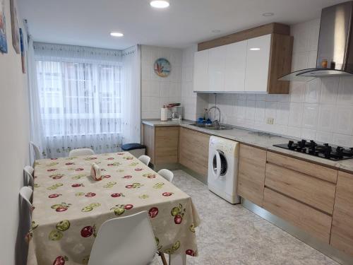kuchnia ze stołem z tkaniną w obiekcie DE Apartamentos Pampin Ponte do Porto w mieście A Coruña
