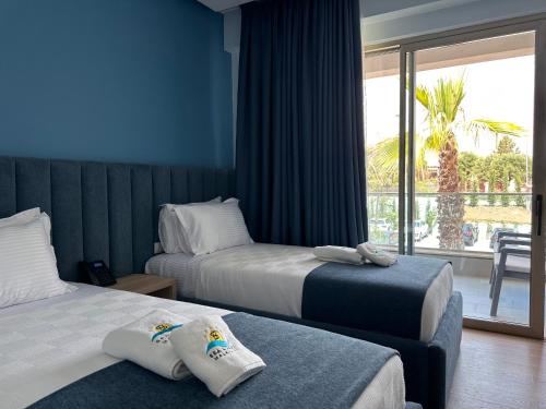 a hotel room with two beds and a balcony at Sea Coast Resort Halkidiki in Yerakiní