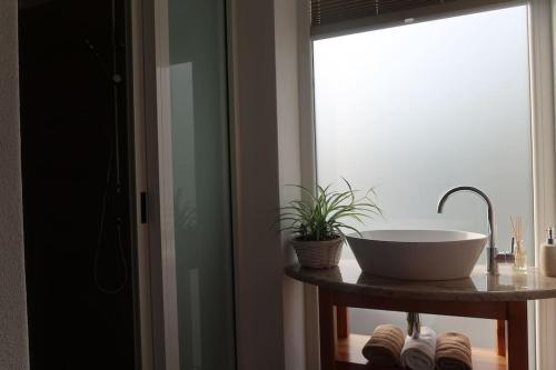 La salle de bains est pourvue d'un lavabo et d'une fenêtre. dans l'établissement Holiday home Dreams, à Kobarid