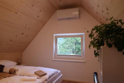 Zimmer im Dachgeschoss mit einem Bett und einem Fenster in der Unterkunft Holiday home Dreams in Kobarid