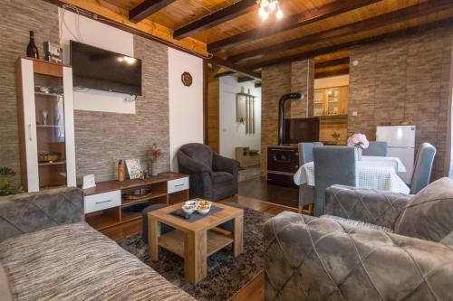 a living room with couches and a table and a kitchen at Brvnara Sofiana in Bajina Bašta