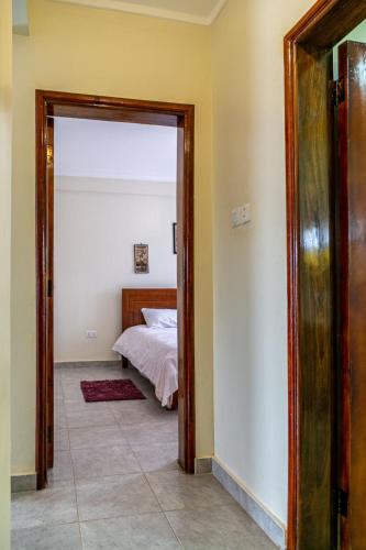 a bedroom with a bed and a large doorway at Eric and Devota apartments Kampala in Buwate