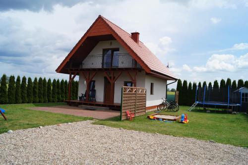 a small house with a porch and a playground at Domki Alex I Maciek in Pleśna
