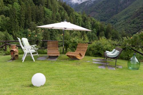 a group of chairs and an umbrella in the grass at B&B22 in Santa Brigida
