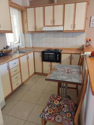 a small kitchen with a table and a microwave at Mixaleas apartments in Kalamata