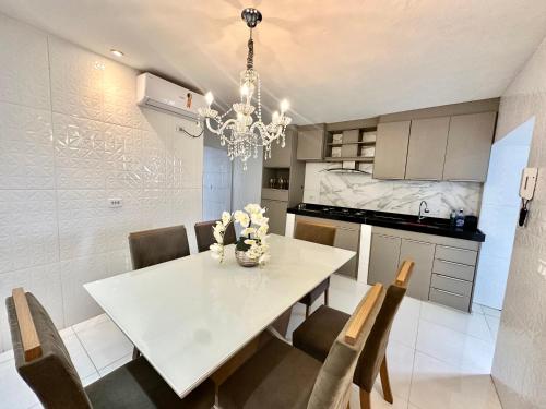 a dining room with a white table and chairs at Casa Parque nacional Serra da capivara in Coronel José Diaz