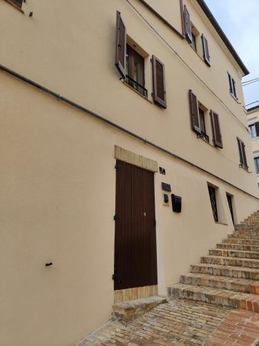 a building with a brown door and some stairs at Dolci Soggiorni in Loreto