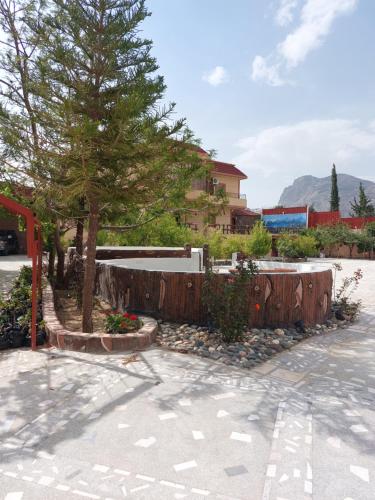 a wooden fence and a tree in a parking lot at فله فاخرة in Tanomah