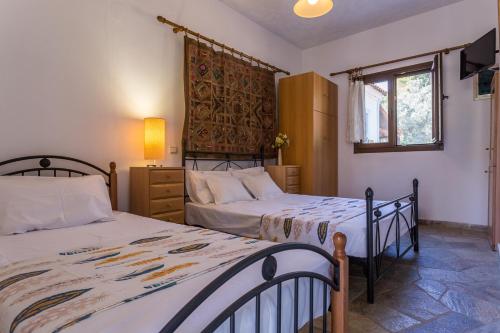 a bedroom with two beds and a window at CalmNature in Agnontas