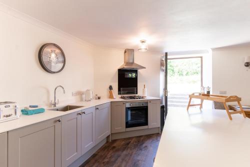 a kitchen with a sink and a stove top oven at Holyland House - Greenacres Estates in Pembrokeshire