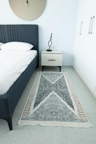 a bedroom with a bed and a table with a star rug at Seaview apartments in Ayios Elias