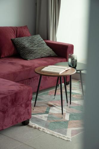 a living room with a red couch and a table at Seaview apartments in Ayios Elias