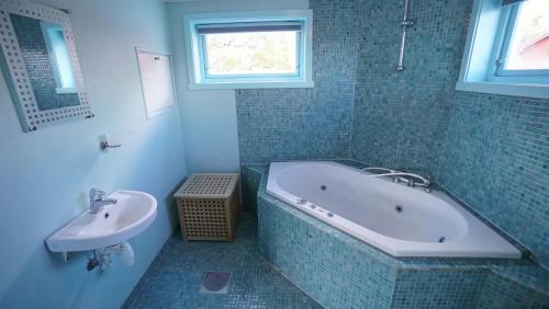 a bathroom with a bath tub and a sink at Real fisherman's cabins in Ballstad, Lofoten in Ballstad