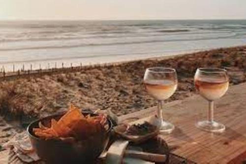 - deux verres de vin assis sur une table près de la plage dans l'établissement Maison au coeur des vignes, à Cussac-Fort-Medoc