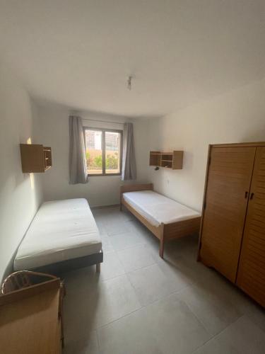 Cette petite chambre comprend 2 lits et une fenêtre. dans l'établissement Loue appartement Piana Corse, à Piana