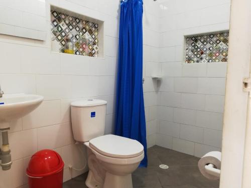 a bathroom with a toilet and a blue shower curtain at Casa Campestre con Piscina Jacuzzi y Golfito in Villavicencio