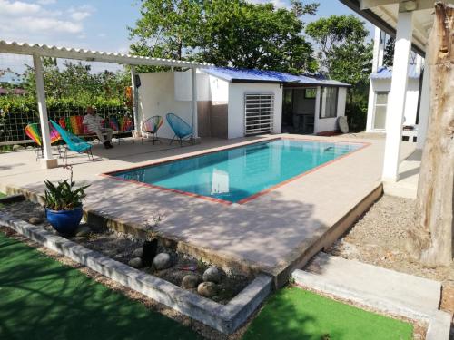 a swimming pool with a deck and a house at Casa Campestre con Piscina Jacuzzi y Golfito in Villavicencio