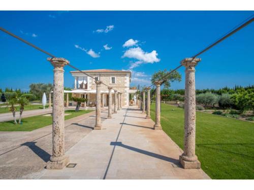 a row of columns on a sidewalk in front of a building at Belvilla by OYO Ses Rentadores in El Port de la Selva