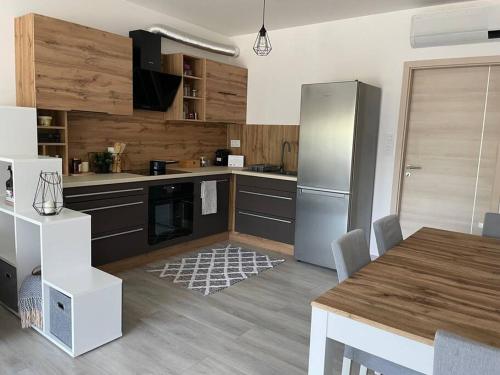 a kitchen with a stainless steel refrigerator and a table at Edisonvilla213 in Fonyód