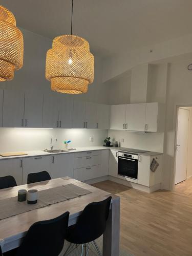 a kitchen with white cabinets and a table with chairs at Apartment in Breiviken in Bergen