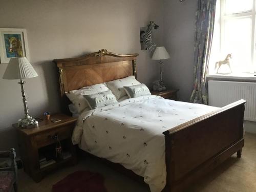 a bedroom with a large bed with a wooden headboard at Plas Bostock Farm in Wrexham