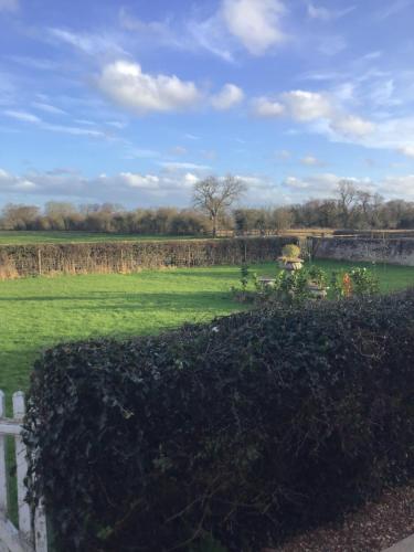 um campo verde com uma cerca e uma ponte em Plas Bostock Farm em Wrexham