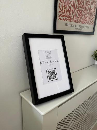 a picture frame sitting on top of a white dresser at Belgrave Studio Apartments, Westminster London in London