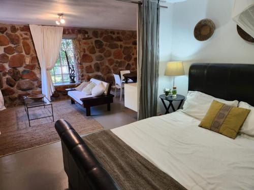 a bedroom with a bed and a living room at The Bardolino Artists Retreat in Nelspruit