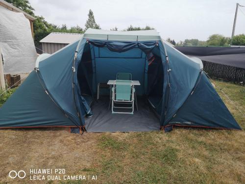 a tent with a table and a chair in it at tente pour 4 personnes in Saint-Jean-de-Monts