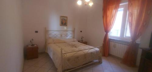 ein kleines Schlafzimmer mit einem Bett und einem Fenster in der Unterkunft Casa Ester in Ascea