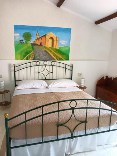 1 dormitorio con 1 cama con una pintura en la pared en Karlin's house Anzi - albergo diffuso, en Anzi