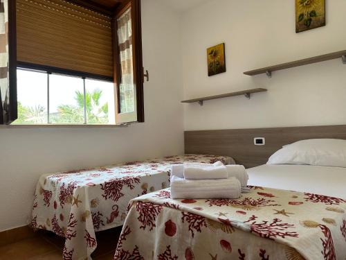 a bedroom with two beds and a window at Salemarino apartment in Terrauzza