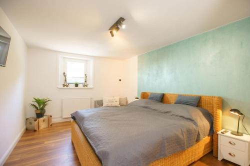 a bedroom with a bed with a blue wall at Ferienwohnung inmitten der Natur 