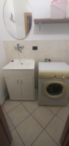 bagno con servizi igienici, lavandino e specchio di Casa Ester ad Ascea