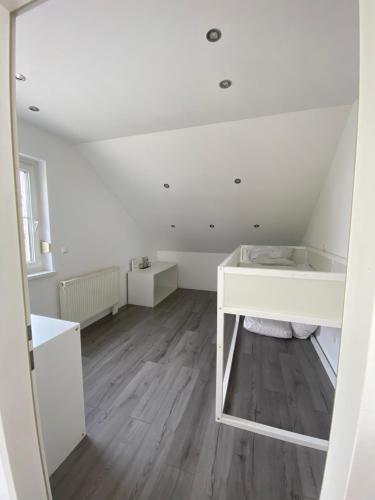 Habitación con escritorio blanco y suelo de madera. en Modernes Haus in Parndorf en Parndorf
