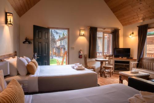 una camera d'albergo con due letti e una televisione di HI Banff Alpine Centre - Hostel a Banff