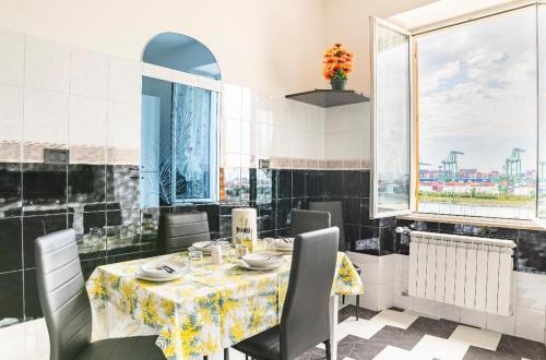 una sala da pranzo con tavolo, sedie e finestre di casa vacanza Laura a Genova
