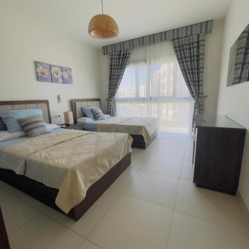um quarto com 2 camas e uma grande janela em شالية بمراسي فرش فندقي السعر شامل الكروت em El Alamein