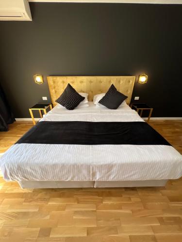a bedroom with a large white bed with black pillows at Krystal Boutique Mansion in Hunedoara