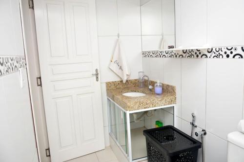 a bathroom with a sink and a white door at Cantinho Bebler in Santa Teresa