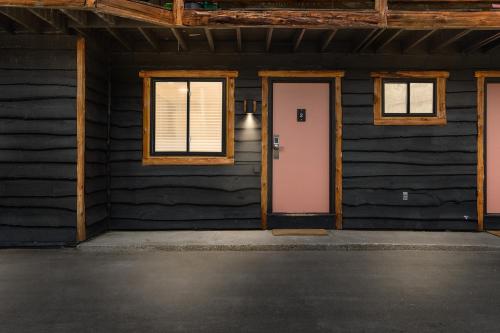 a room with a pink door in a black house at The Boha Hotel in Lake Placid