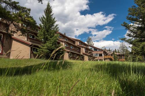 a building in the middle of a field of grass at HI Banff Alpine Centre - Hostel in Banff