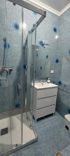 a bathroom with a glass shower and a sink at Piso Ribeira Sacra in Monforte de Lemos