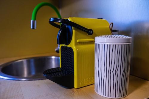 a yellow kitchen mixer next to a cup on a counter at Porta Green in Budapest