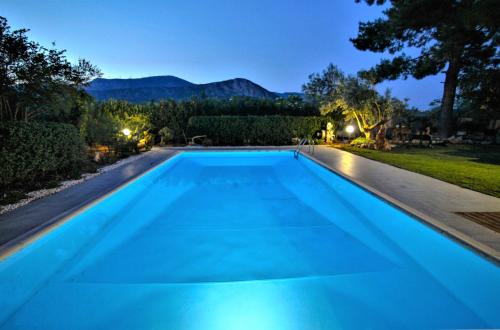 a swimming pool in the backyard of a house at night at Villa Korina in Metókhion