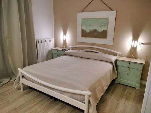 - une chambre avec un lit blanc et 2 tables de chevet dans l'établissement Lusso Gallipoli confort ed eleganza, à Galatina