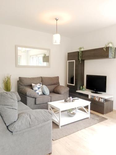 a living room with a couch and a tv at La Casa de Marina in Viveiro