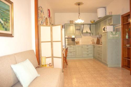 uma sala de estar com um sofá e uma cozinha em A Casa di Ale em Sorso