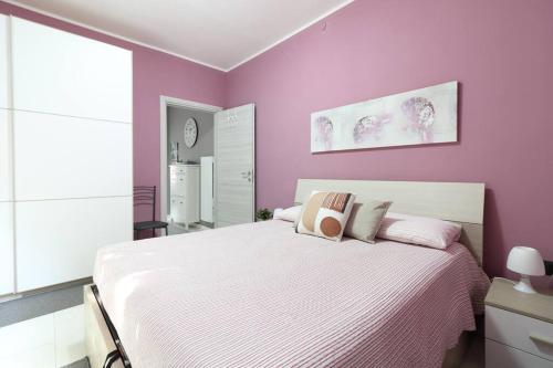 a bedroom with purple walls and a large bed at Lake House Valeriana in Pilzone